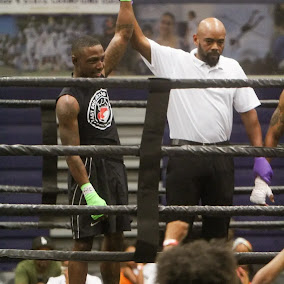 Referee raising a young fighter's hand in victory